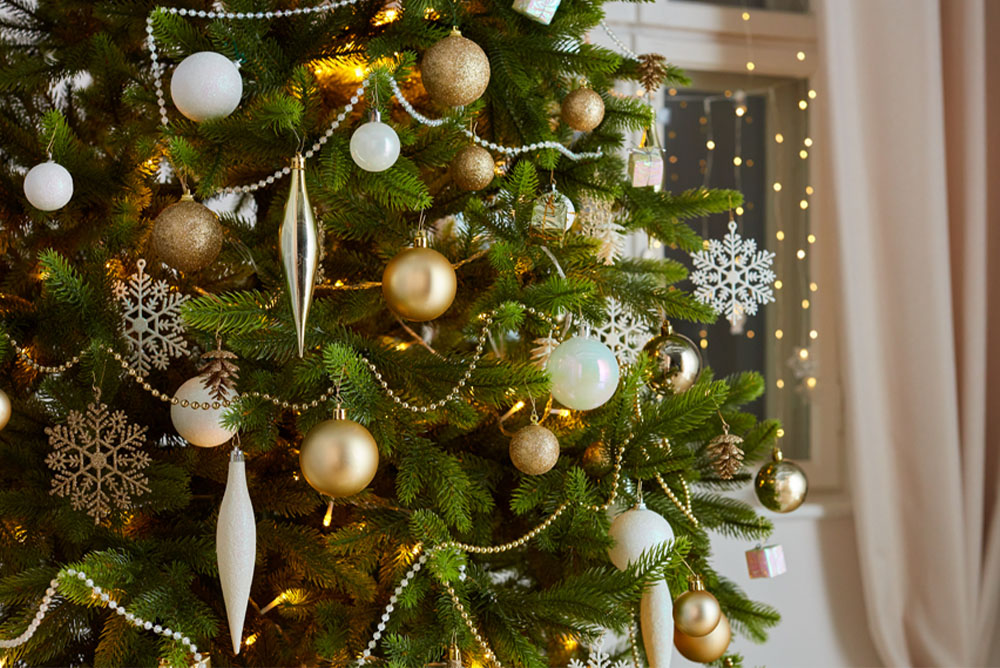 Pom de Crăciun cu ornamente în auriu, argintiu și alb.
