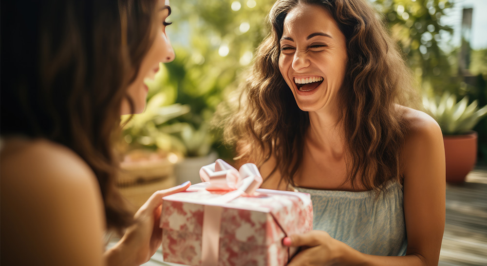 O femeie zâmbitoare prezintă un cadou unui prieten.