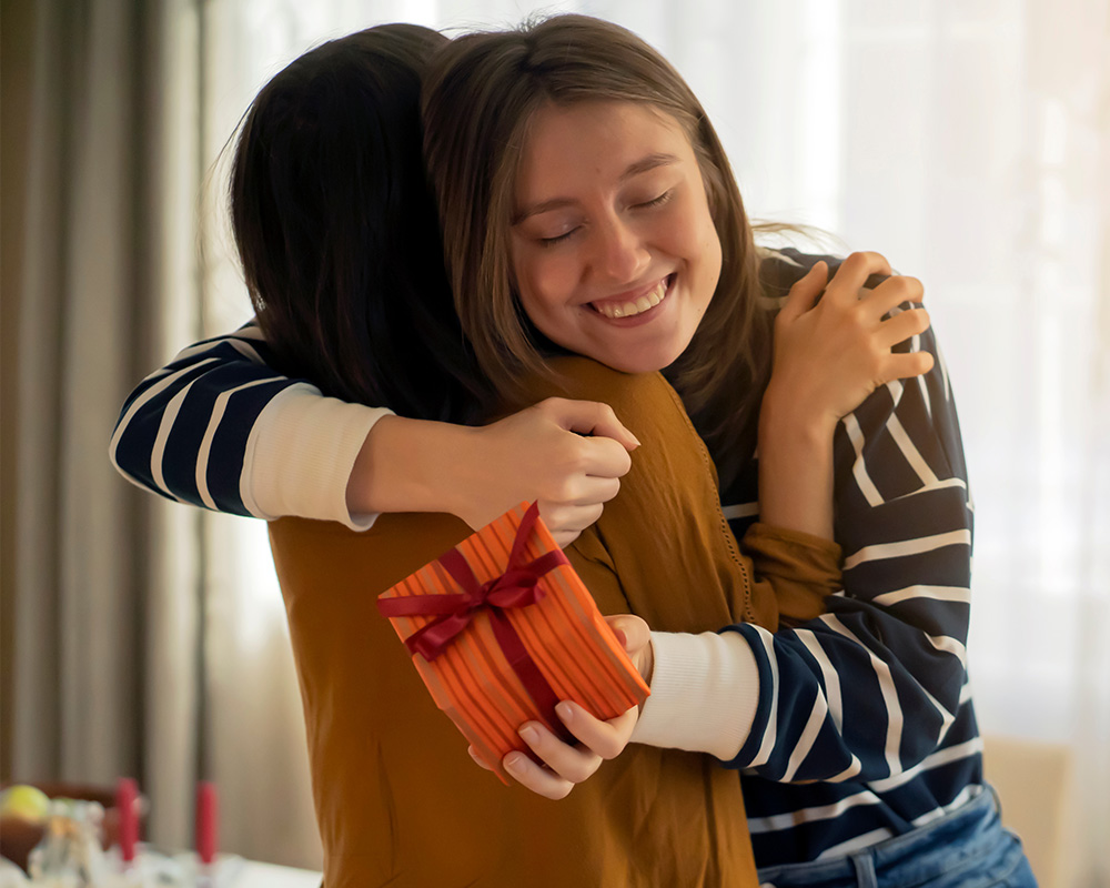 O fată oferă un cadou surorii sale și, de asemenea, unui prieten.
