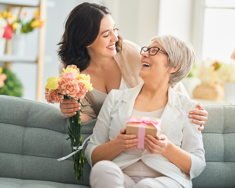Fiica adultă îi oferă bătrânei sale mame un buchet de flori