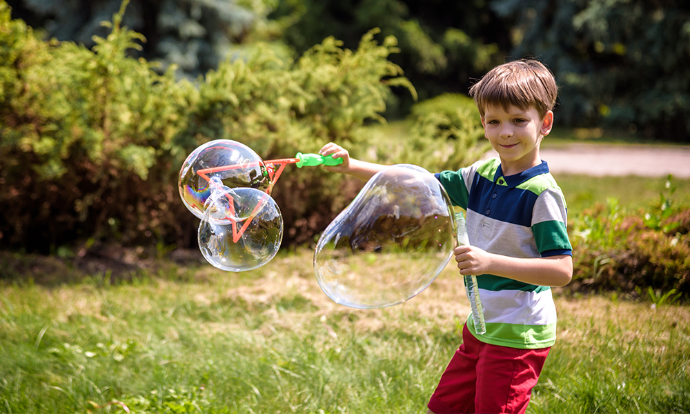 Băiat care face baloane de săpun